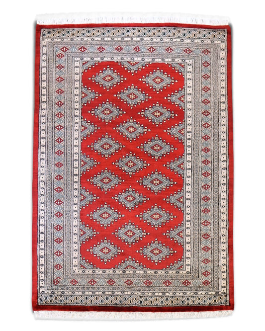 Decorworks hand-woven Pakistani wool rug in red with traditional geometric diamond patterns and intricate borders